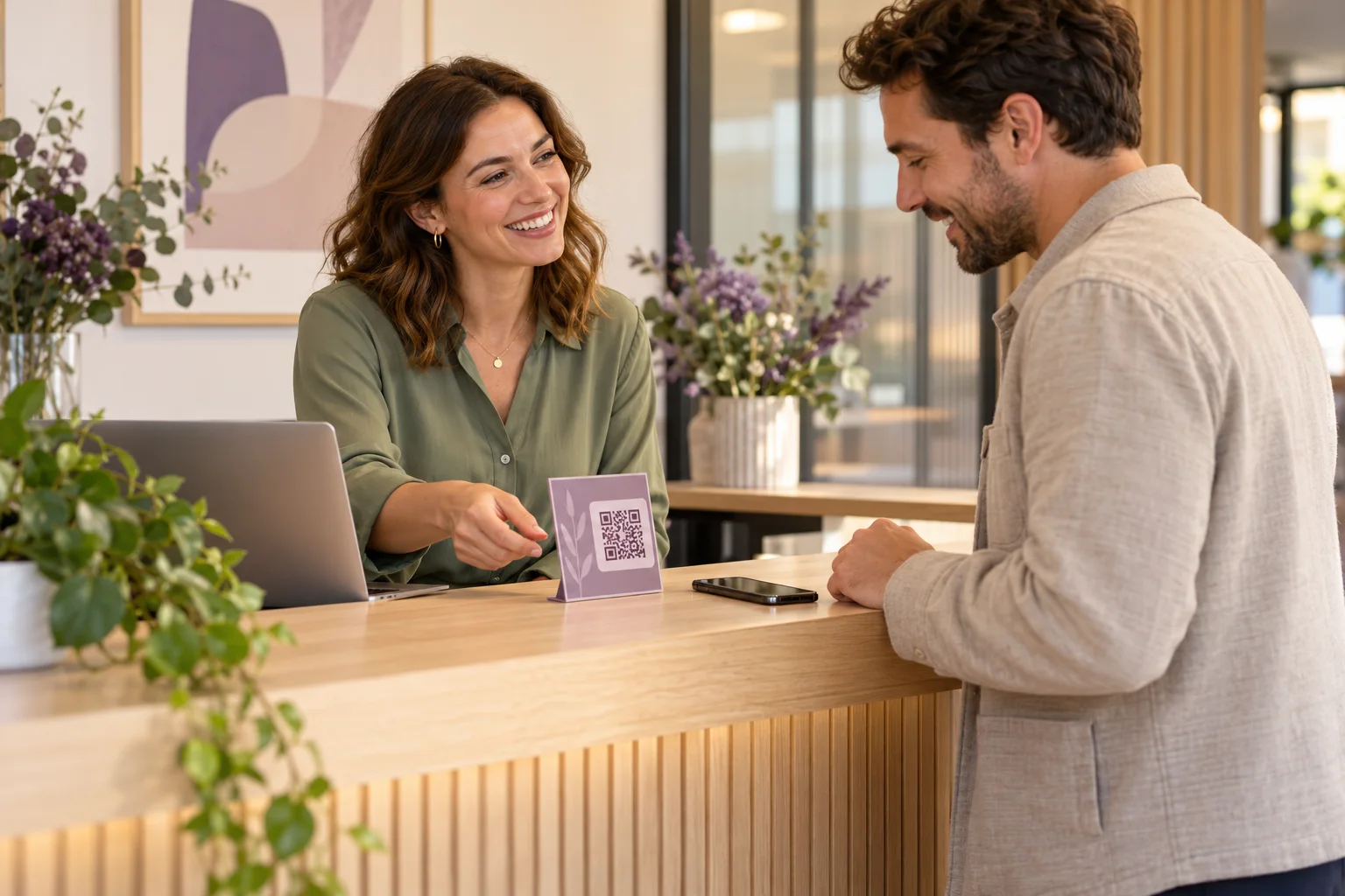 An independent service business owner inviting a visitor to share feedback beside a QR placard